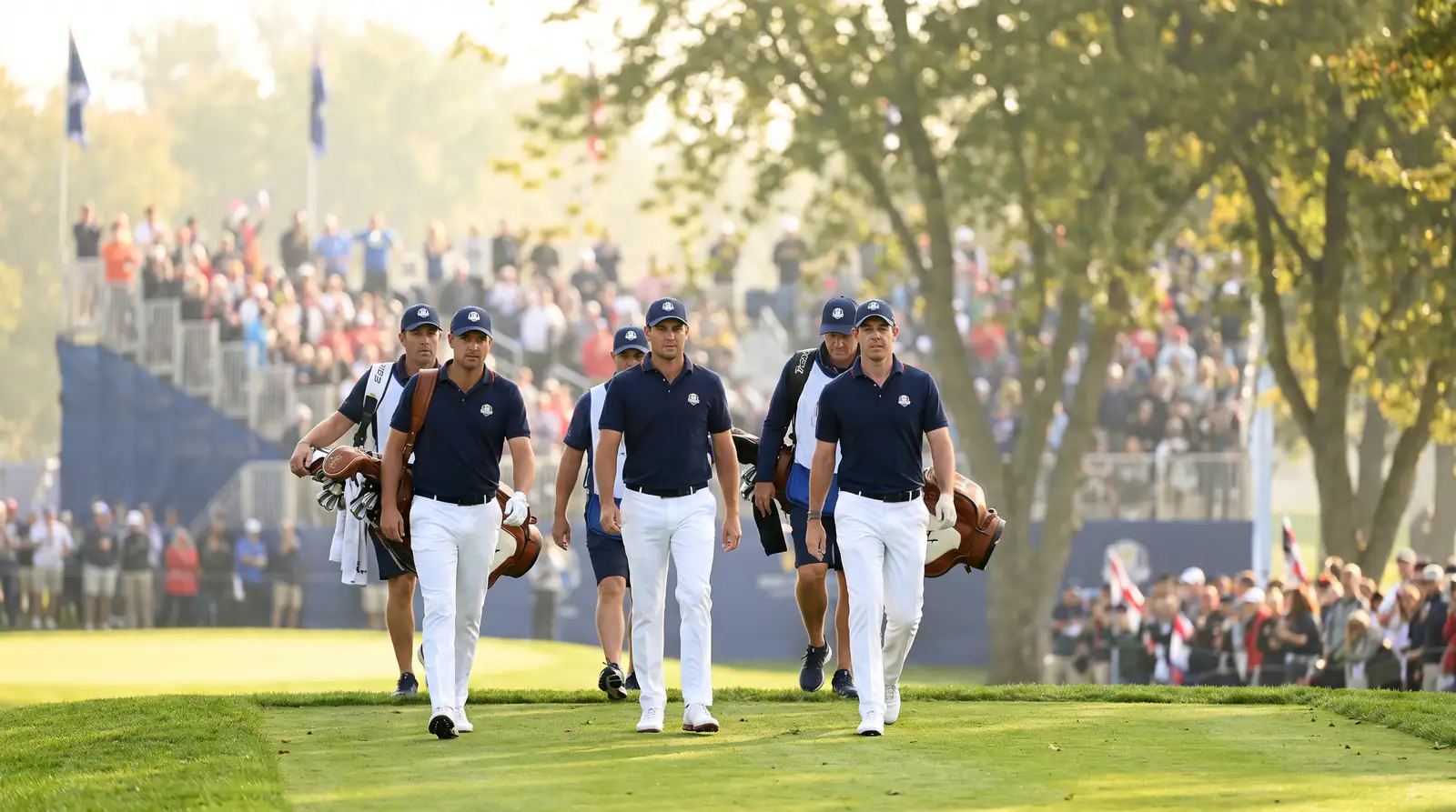 European Ryder Cup team members in matching navy team kit walking out together onto an opening tee